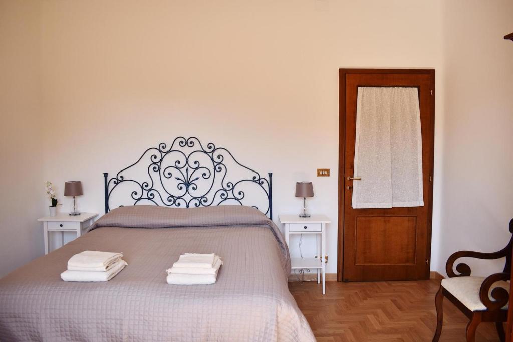 sypialnia z łóżkiem i ręcznikami w obiekcie La Finestra su Siena w Sienie
