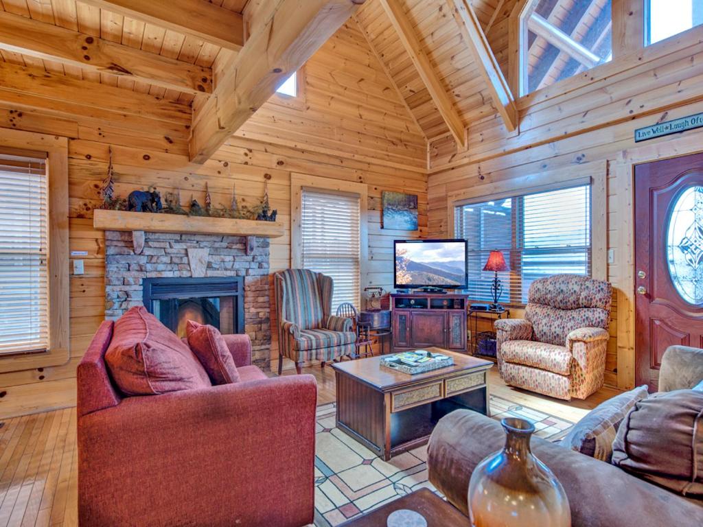 a living room with a fireplace in a log cabin at Misty Mountain Hideaway, 3 Bedrooms, Sleeps 10, Pool Access, WiFi in Pigeon Forge