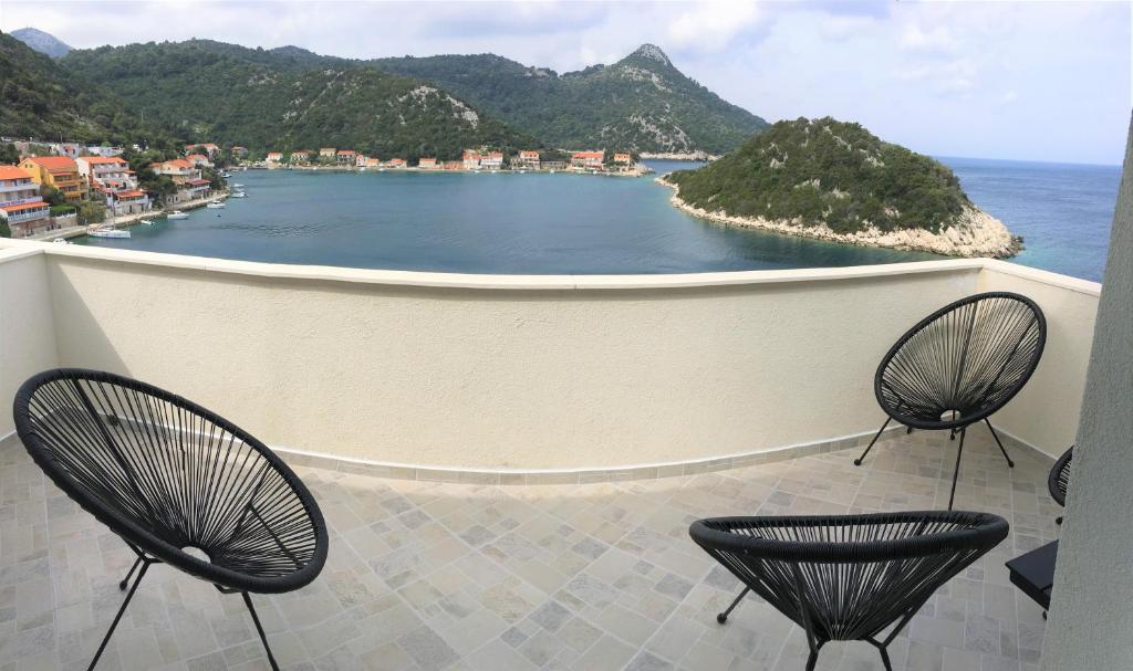 a balcony with two chairs and a view of the ocean at Apartments Kurelja in Lastovo