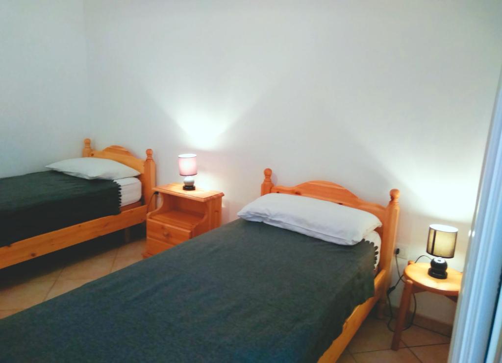 レウカにあるCasa vacanza Leucaのベッドルーム1室(ベッド2台、ランプ2つ付)