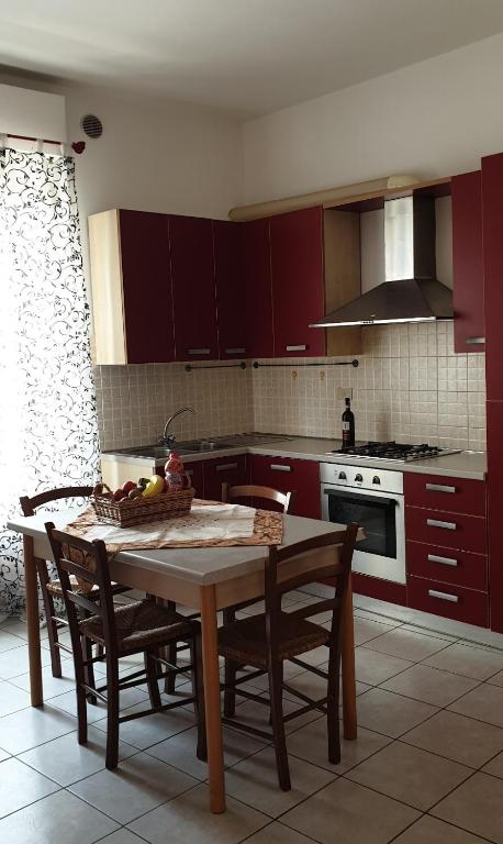 kuchnia ze stołem i miską owoców w obiekcie Ladybug Apartment w mieście Poggibonsi