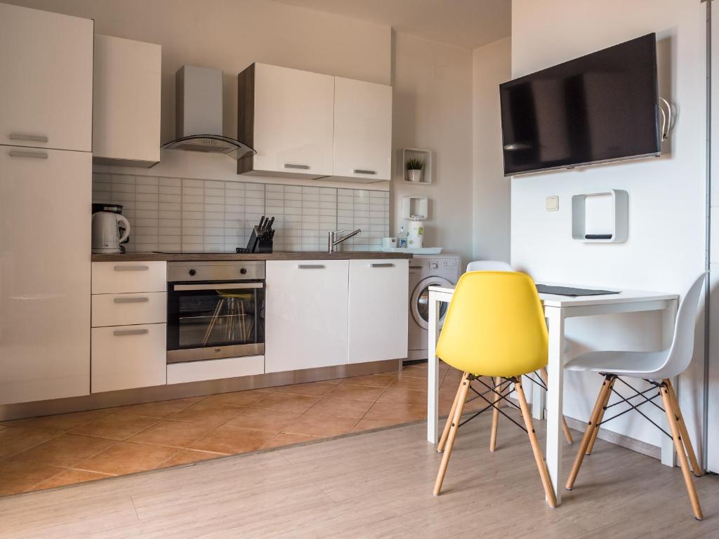 a kitchen with a yellow chair and a table at Apartments Nino 1 in Zadar