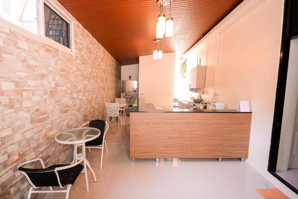 U-need Guesthouse95 في بانكوك: مطبخ وغرفة طعام بجدار من الطوب