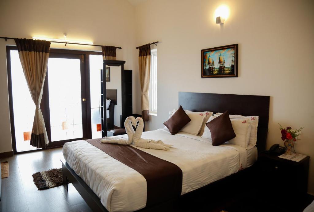 a bedroom with a large bed with a large window at Paradise Perfect in Ooty