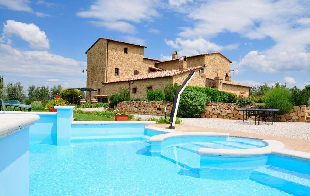 una casa con piscina frente a un edificio en Agriturismo Il Macchione, en Pienza