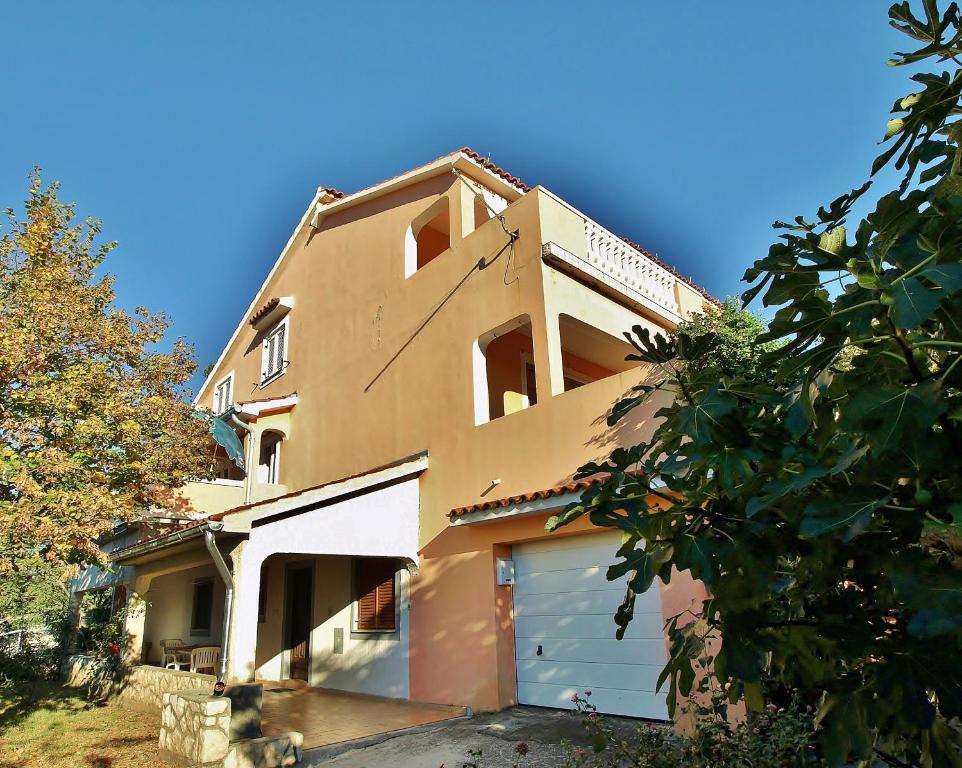 a building with two garage doors and a sky at Feniks Apartmani Lopar in Lopar