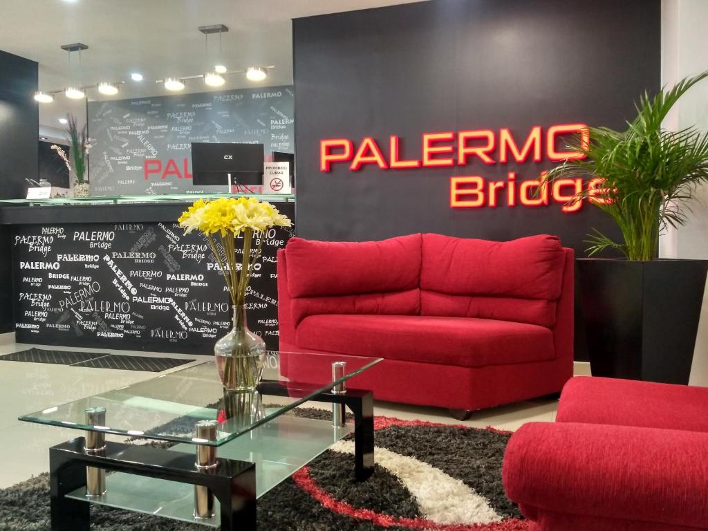 sala de estar con sofá rojo y mesa en Palermo Bridge en Buenos Aires