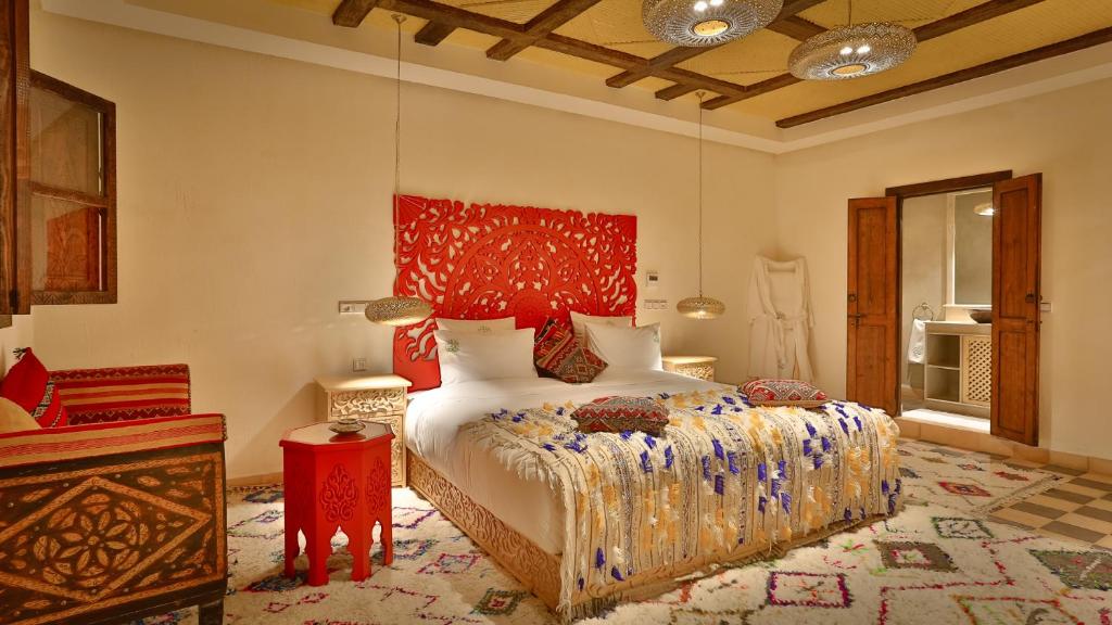 a bedroom with a bed with a red headboard at ferme by Ikalimo in Ourika