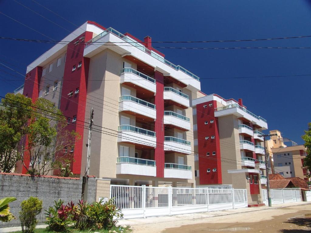 a large apartment building with red and white at Condomínio Pedra Coral in Ubatuba