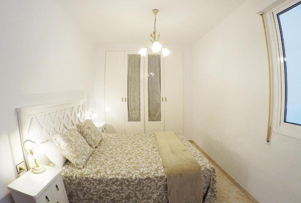 a white bedroom with a bed and a window at Apartamento EuroRental con WiFi in Santa Cruz de Tenerife