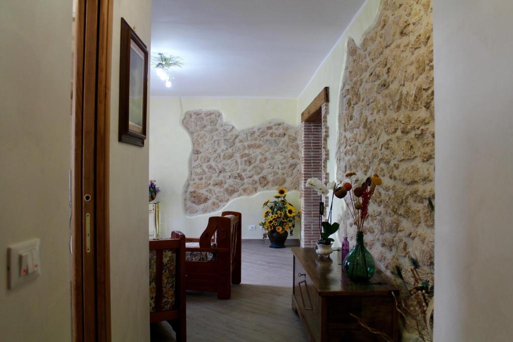 a hallway with a stone wall and a chair and a table at Casa San Giacomo in Poggio Bustone