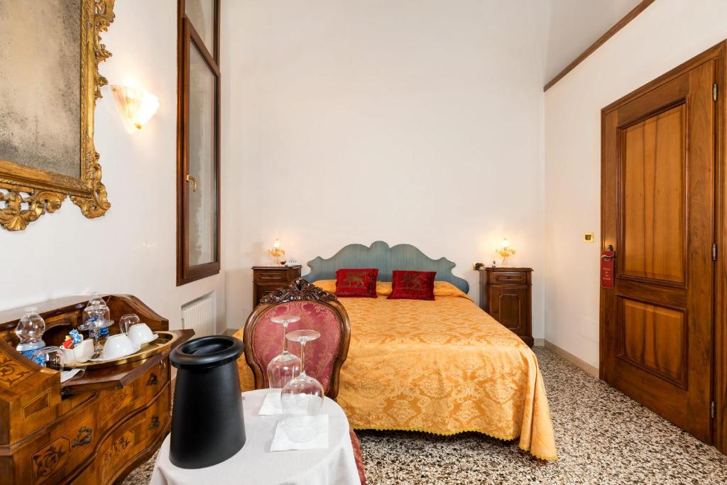 a bedroom with a bed and a wooden dresser at Luxury Venetian Rooms in Venice