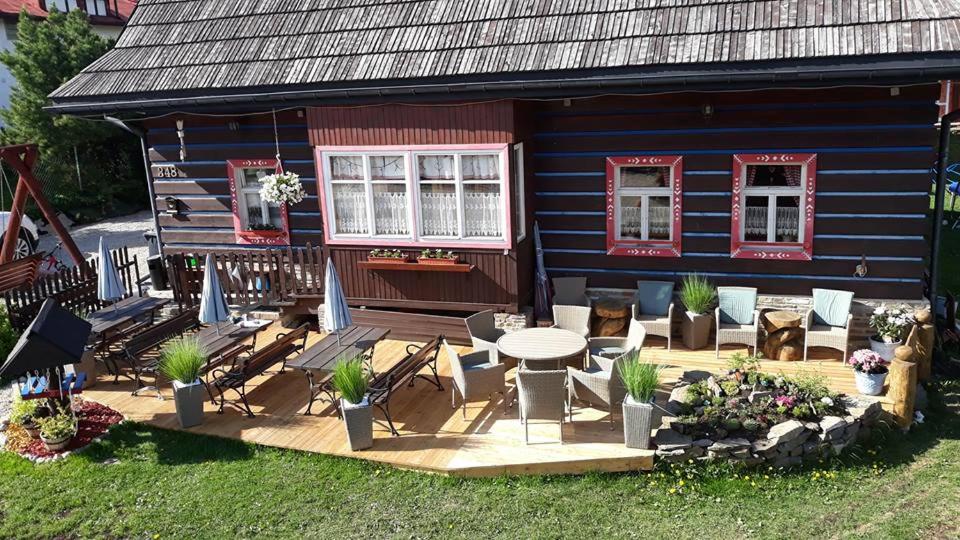 une maison avec une terrasse, une table et des chaises dans l'établissement Pension Aja, à Ždiar