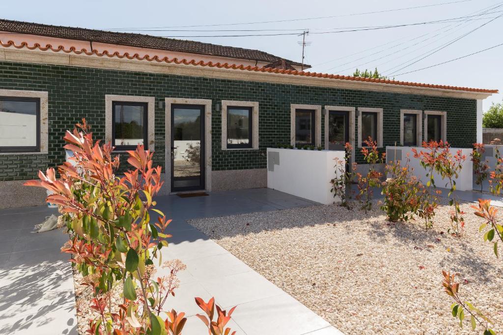 a green brick house with a garden in front of it at Green Villas Douro in Gondomar