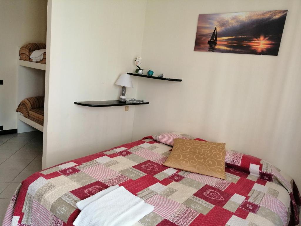 een slaapkamer met een bed met een quilt bij Appartamento per vacanze GAIA in Monterosso al Mare