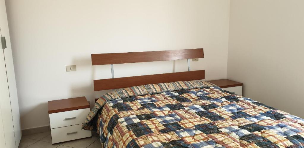 sypialnia z łóżkiem z kołdrą w obiekcie Ladybug Apartment w mieście Poggibonsi
