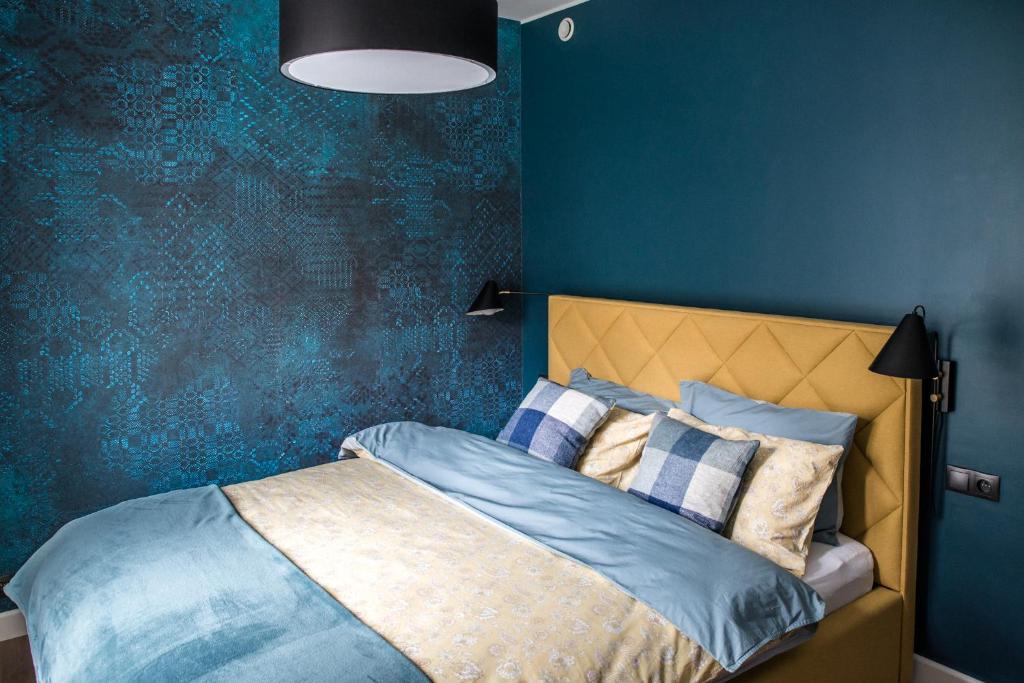 1 dormitorio con 1 cama con pared azul en Augustiańska, en Cracovia