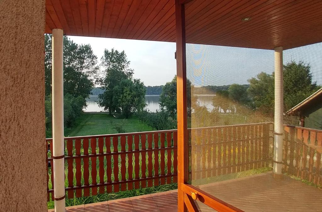 a screened in porch with a view of a lake at Apartman Dunav in Aljmaš