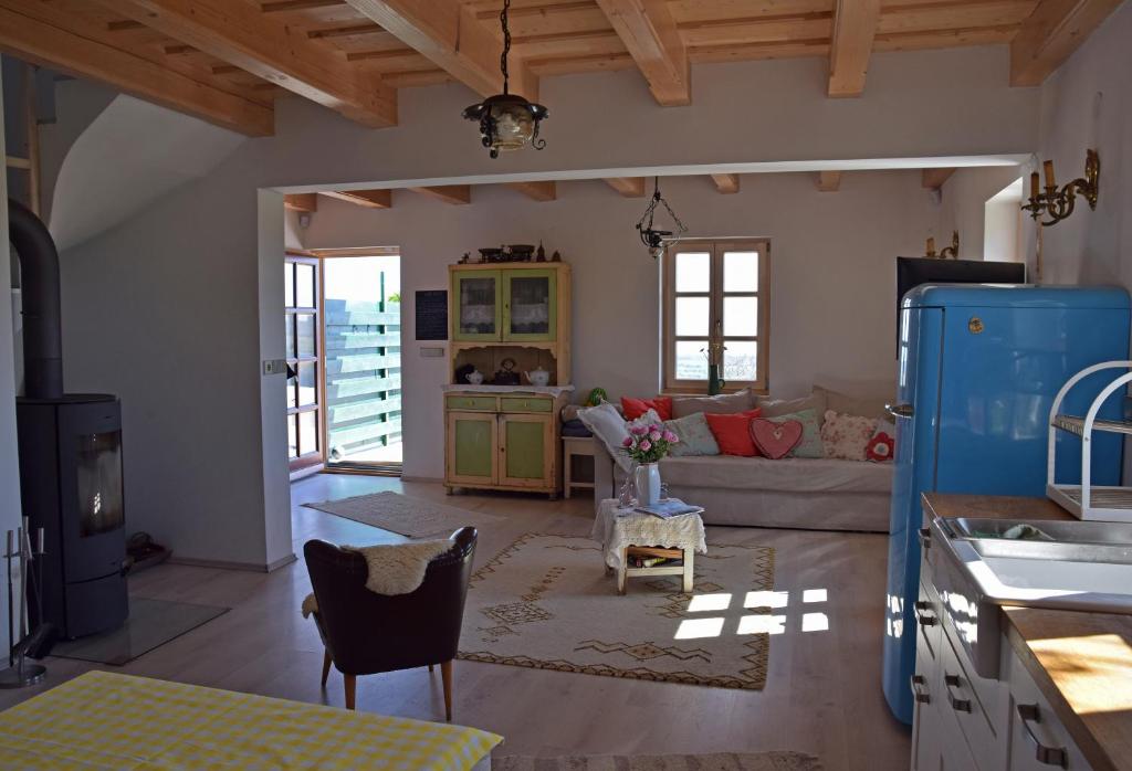kuchnia i salon z kanapą i stołem w obiekcie Panorama, Balaton w mieście Dörgicse