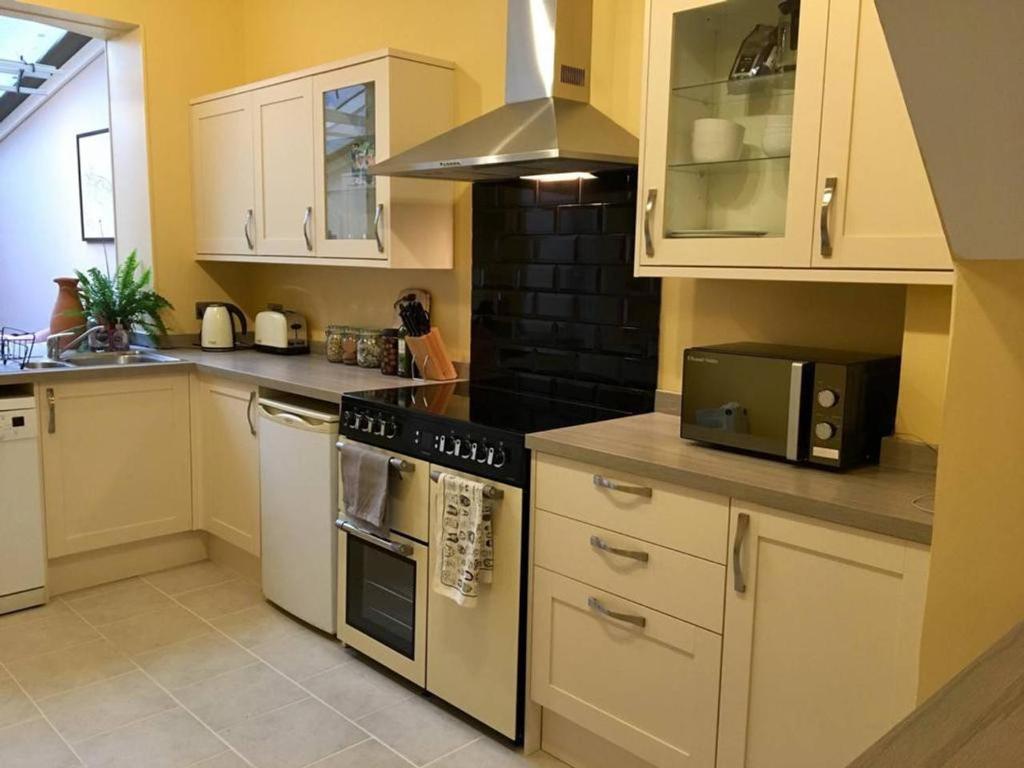 a kitchen with white cabinets and a stove top oven at Cathedral View in Salisbury