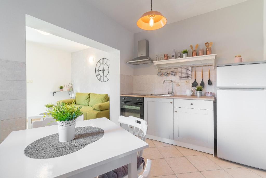 eine Küche mit einer weißen Arbeitsplatte und einem Tisch in der Unterkunft Mediterranean House by The Beach in Posedarje