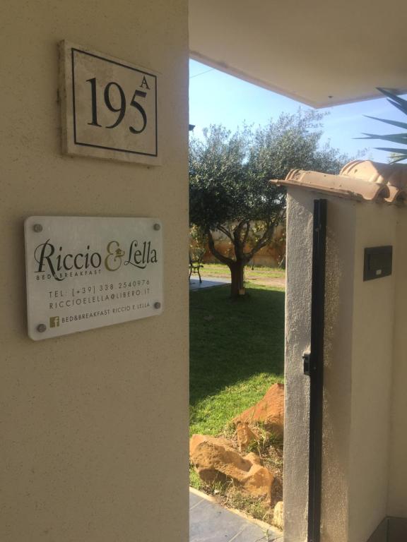 een bord aan de zijkant van een gebouw naast een deur bij Bed&Breakfast Riccio&Lella in Fiumicino