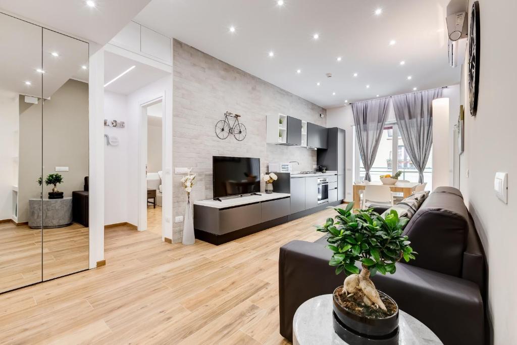a living room with a black couch and a kitchen at San Pietro Vatican Apartments in Rome
