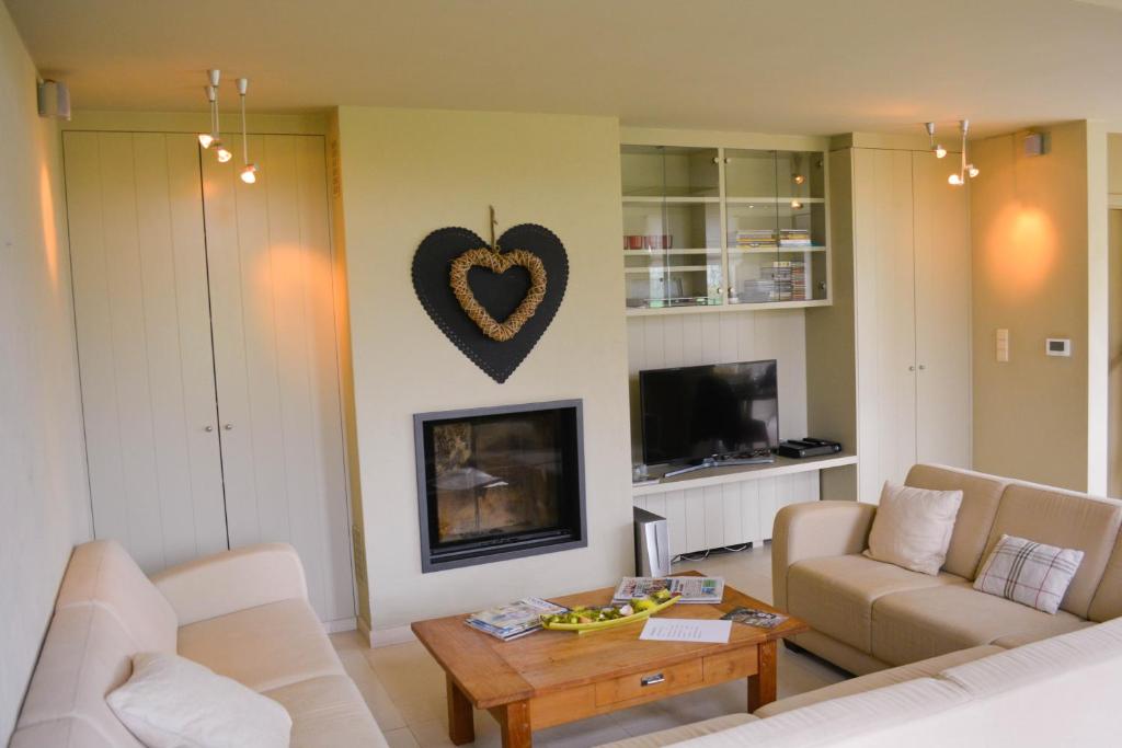 a living room with a heart hanging on the wall at B&amp;B Onderweg in Horebeke