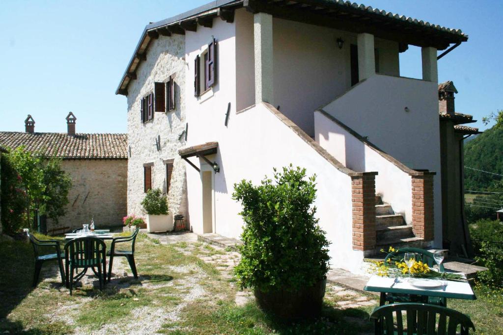 ein Haus mit einem Tisch und Stühlen im Hof in der Unterkunft Borgo Di Fonni in Sellano