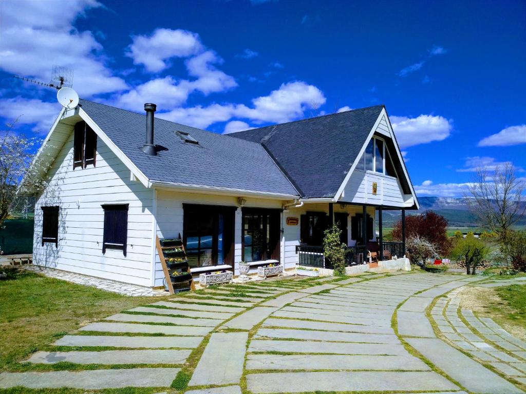 una casa blanca con un camino delante de ella en Casa - Chalet Madera Canadiense, en Santa Cruz de Campezo