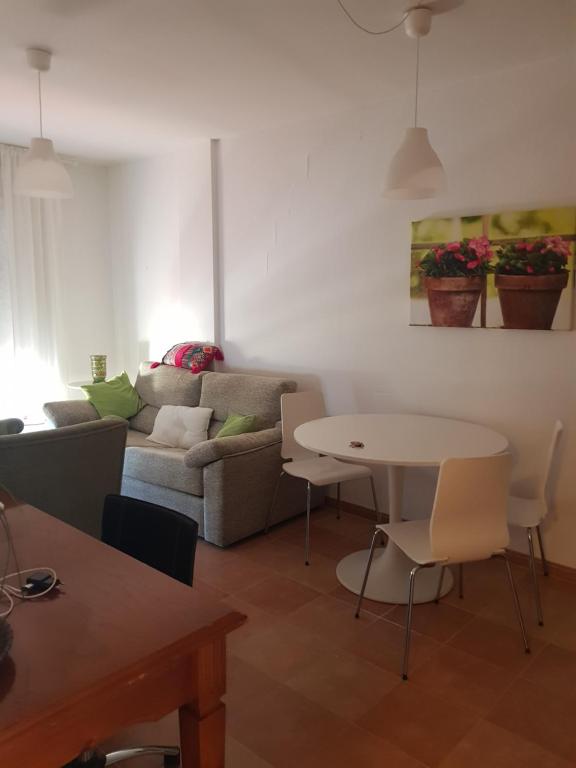 uma sala de estar com um sofá e uma mesa em Apartamento 2dorm Montaña y Playa em Enix