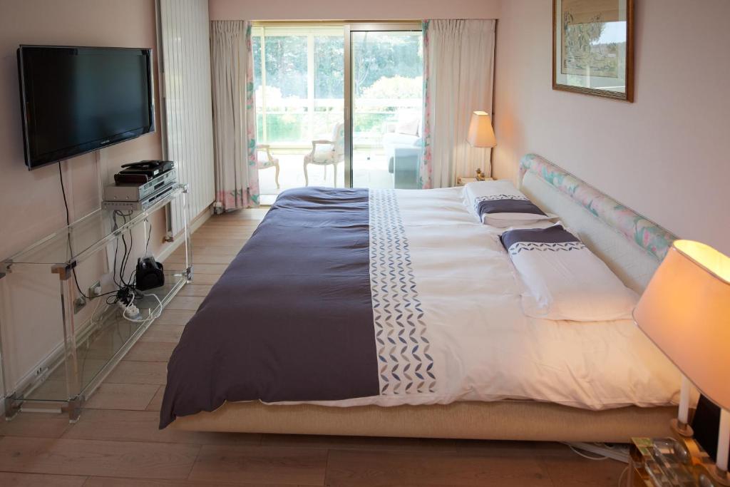 カンヌにあるAppartement Luxueux 150m2 - Cannesのベッドルーム(大型ベッド1台、テレビ付)
