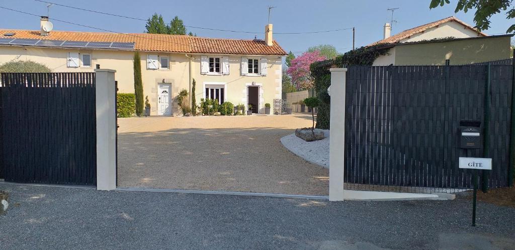 a gate in front of a house with a driveway at la bouquetiere in Mazières-en-Gâtine