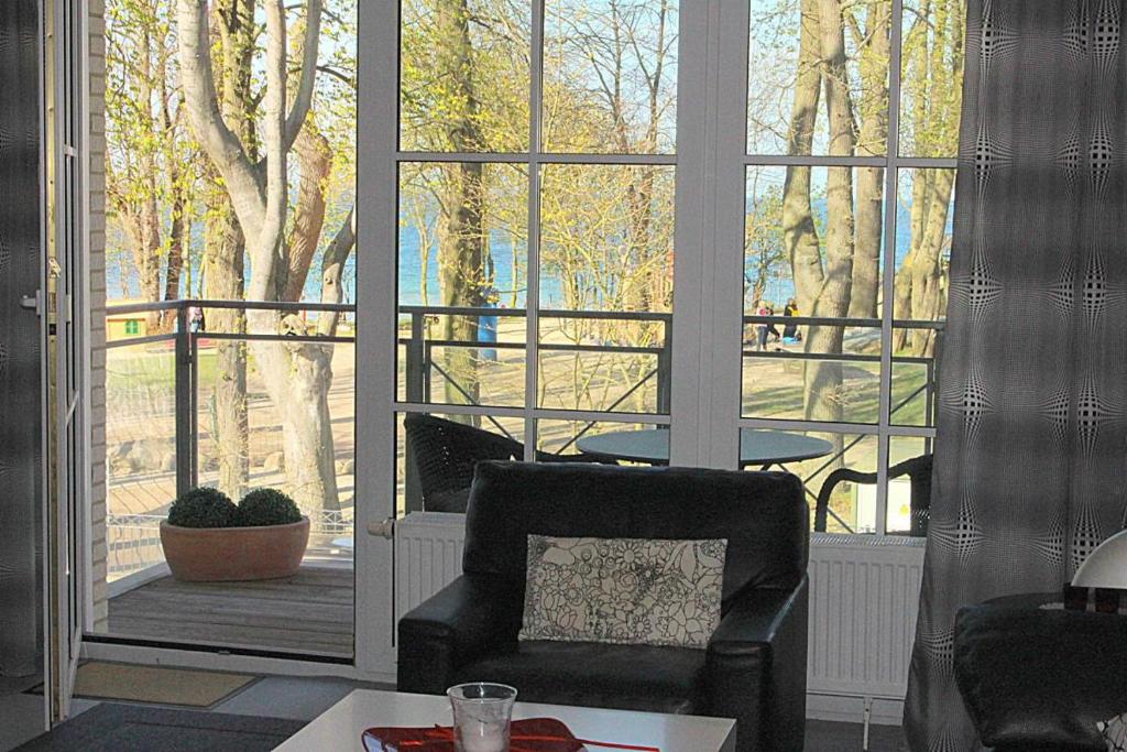 a living room with a chair and a large window at Apartmentvermittlung Mehr als Meer - Objekt 77 in Niendorf