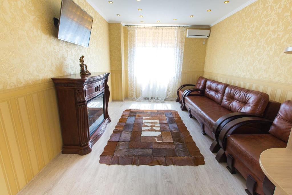 salon ze skórzaną kanapą i telewizorem w obiekcie Квартира в Одессе w Odessie