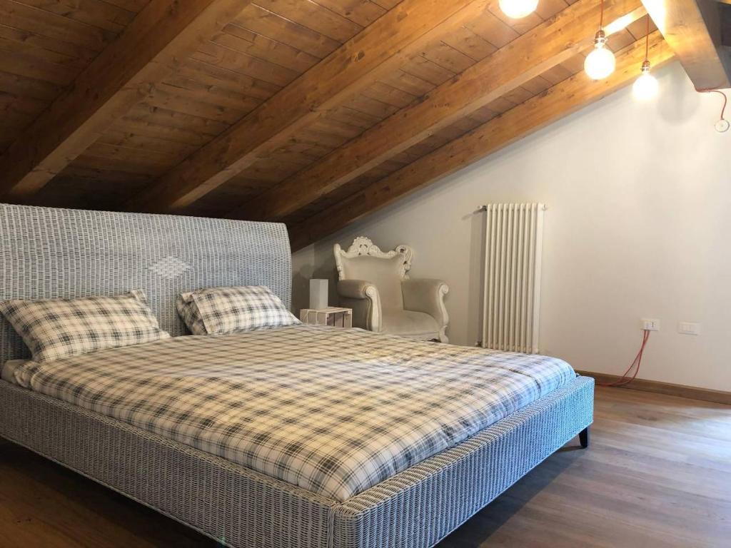 ein Schlafzimmer mit einem Bett und einer Holzdecke in der Unterkunft Casa di Miele in Pinerolo