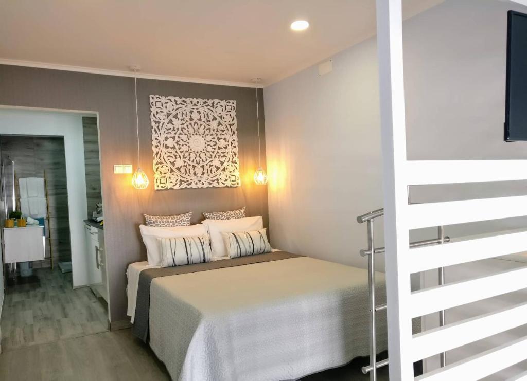 een slaapkamer met een bed met witte lakens en kussens bij V4 in Horta