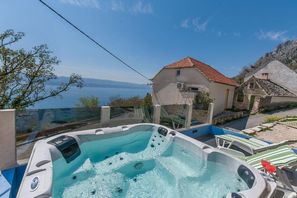 einen Whirlpool auf dem Balkon mit Blick auf das Wasser in der Unterkunft House Darijo in Lokva Rogoznica