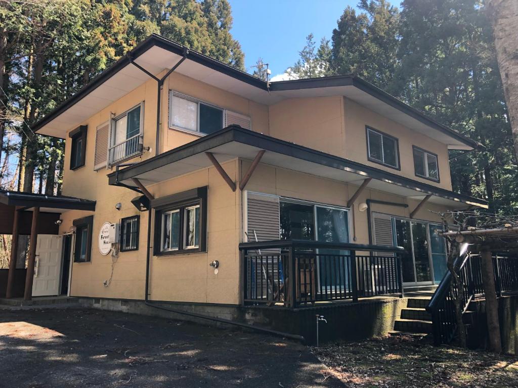 uma casa com um alpendre e uma varanda em Forest House Yamanakako em Yamanakako