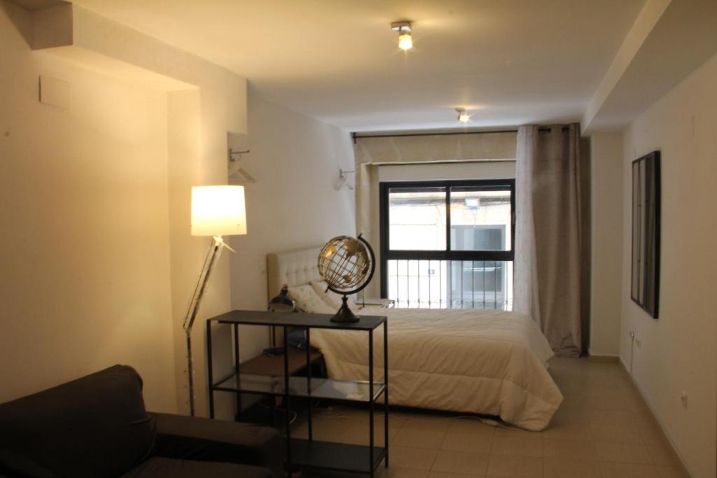 a bedroom with a bed and a lamp and a window at Sunny Apartments, Historical Centre Alicante in Alicante