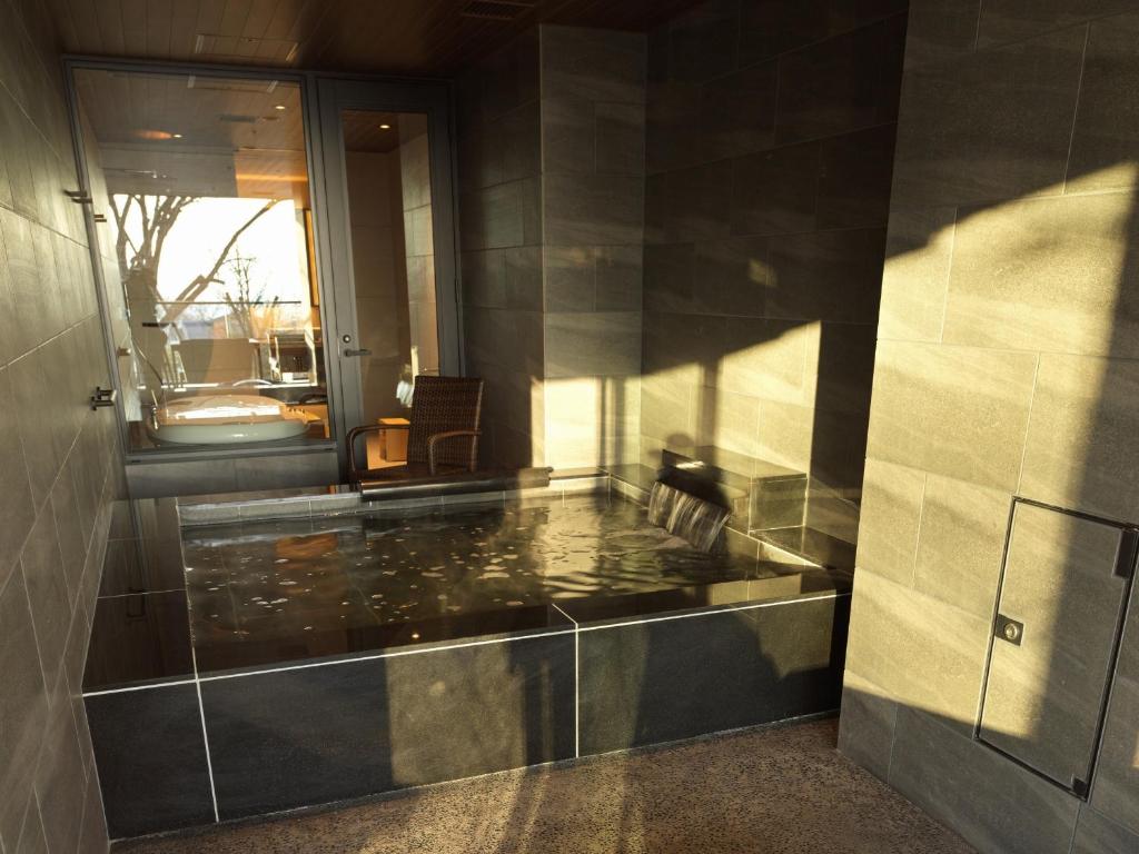 une piscine au milieu d'un immeuble dans l'établissement Lake Shikotsu Tsuruga Bessou AO no ZA, à Chitose