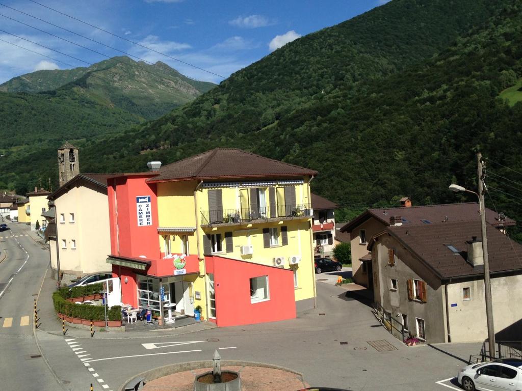 a town with colorful houses and a mountain at Hotel Ristorante Camoghe in Isone