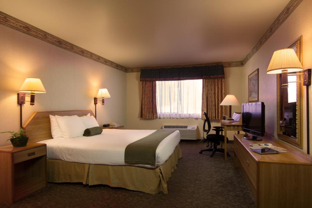 a hotel room with a bed and a desk and a television at The Redwood Riverwalk, a boutique hotel in Fortuna
