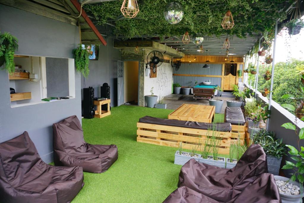 a room with green grass and furniture and plants at Kokos Hostel Padang City in Padang