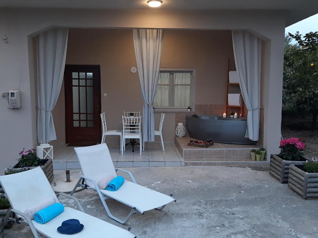 a patio with two chairs and a bath tub at Mommy's House in Angeliana