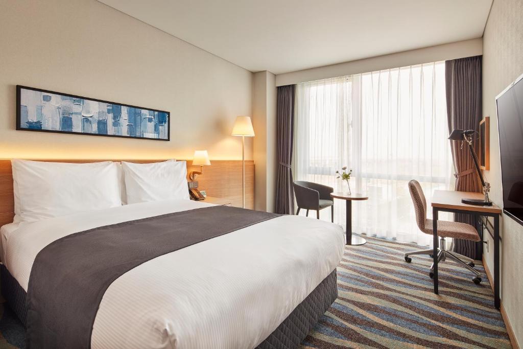 Postel nebo postele na pokoji v ubytování Ramada Encore by Wyndham Gimpo Han River Hotel