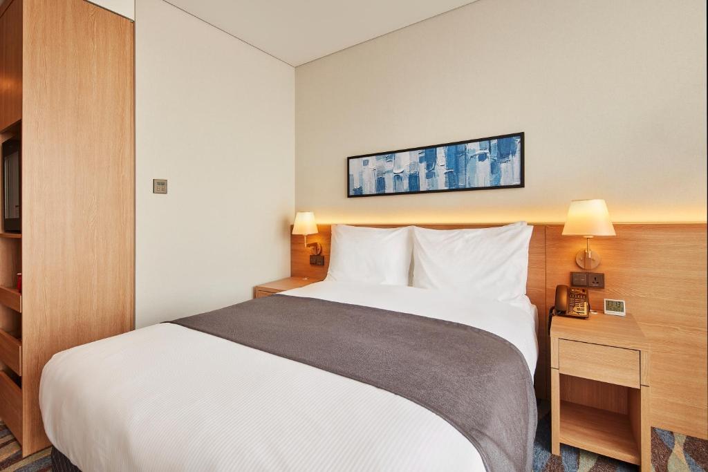 Postel nebo postele na pokoji v ubytování Ramada Encore by Wyndham Gimpo Han River Hotel