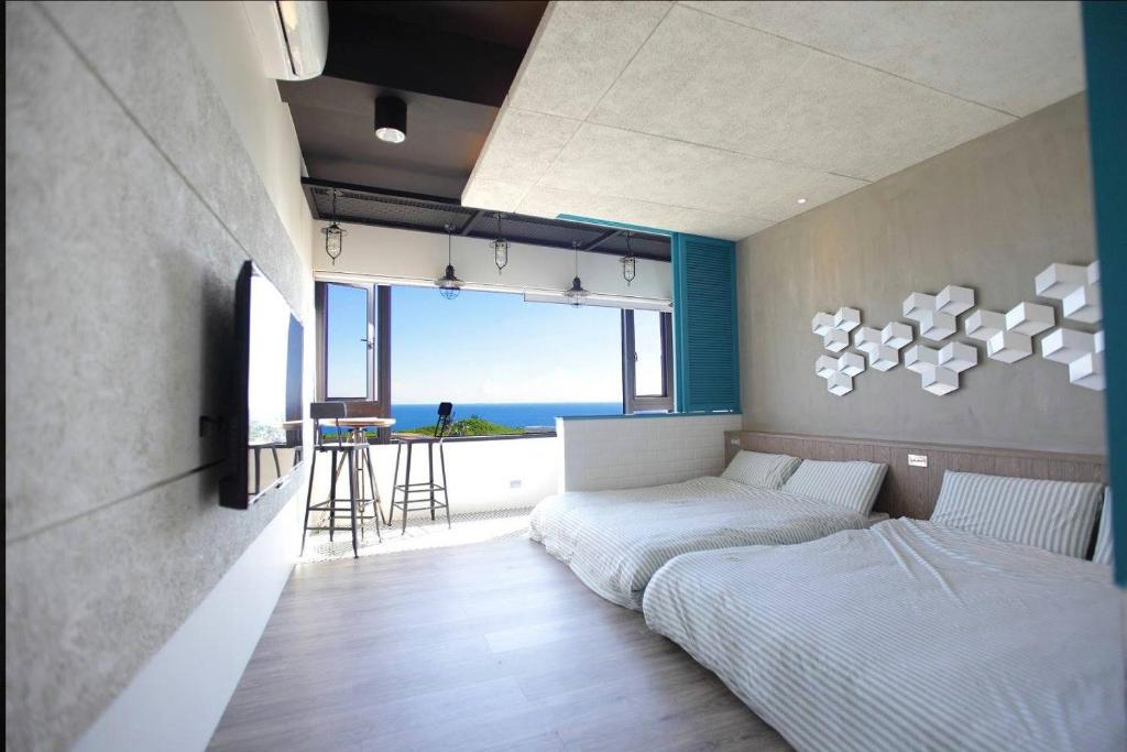 a bedroom with two beds and a view of the ocean at 琉球茶室 現代館 in Xiaoliuqiu