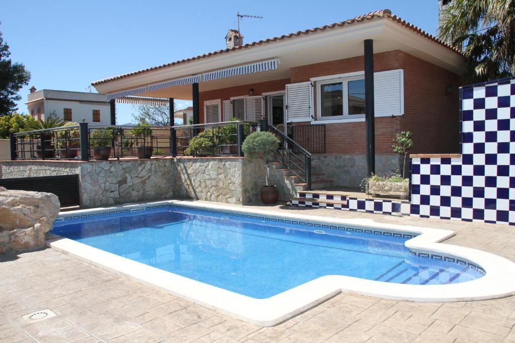 a swimming pool in front of a house at Chalet con piscina privada en zona tranquila de Cambrils in Cambrils