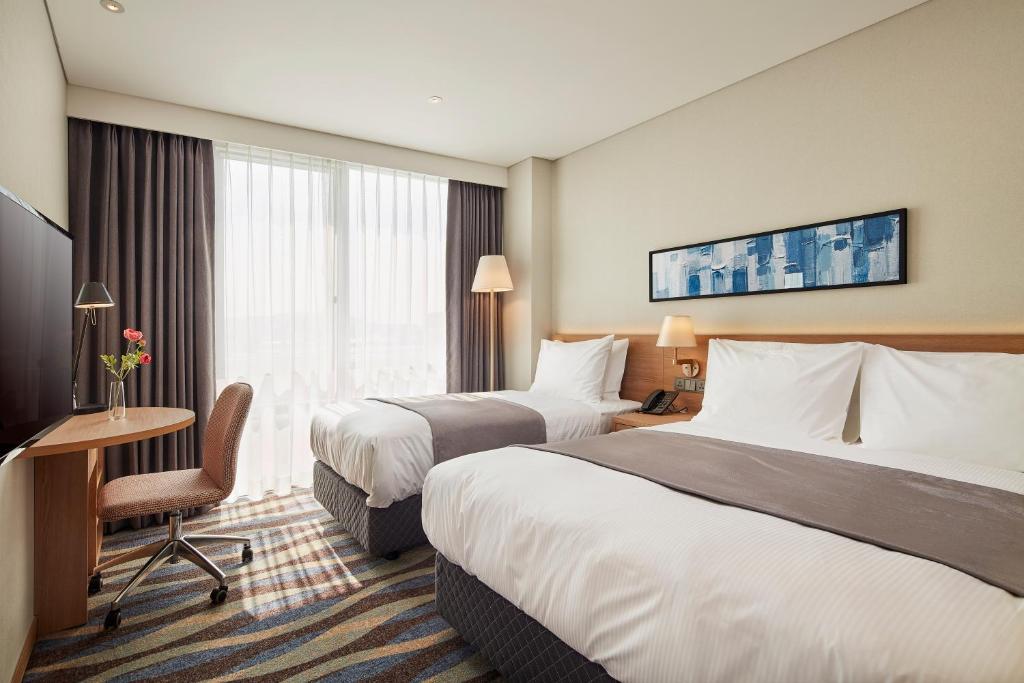Postel nebo postele na pokoji v ubytování Ramada Encore by Wyndham Gimpo Han River Hotel